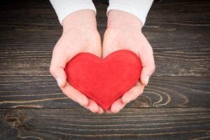 A person holding a heart in their hands.